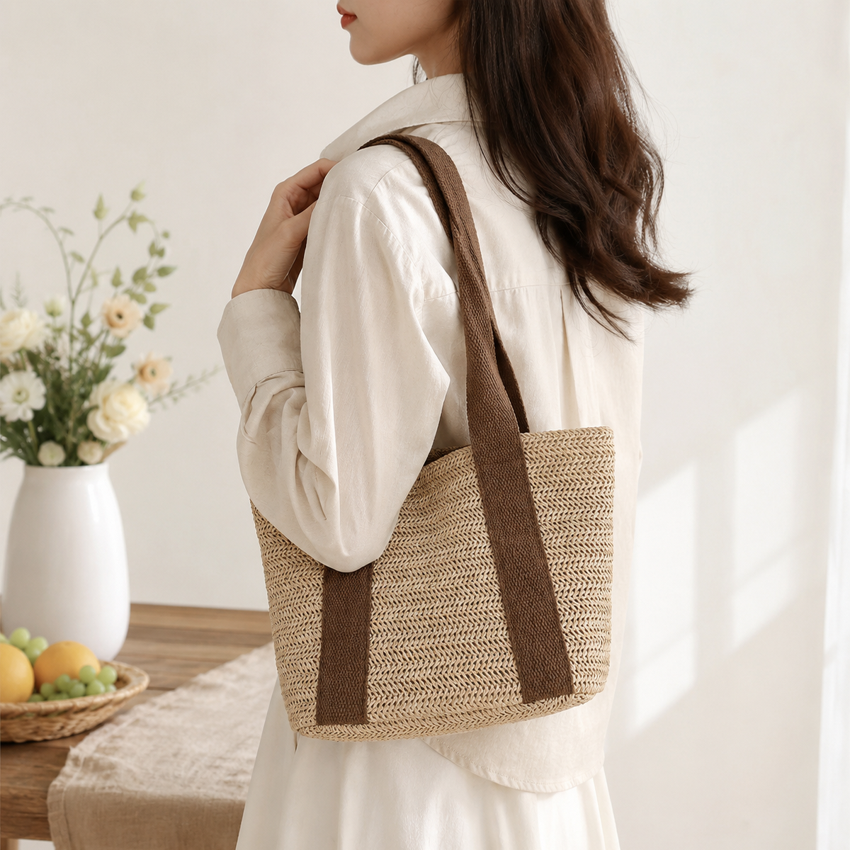 Woman holding a woven bag with a neutral background
