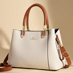White handbag with brown handles and strap on a beige background