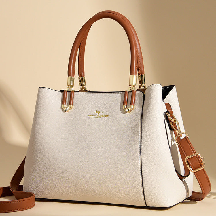 White handbag with brown handles and strap on a beige background