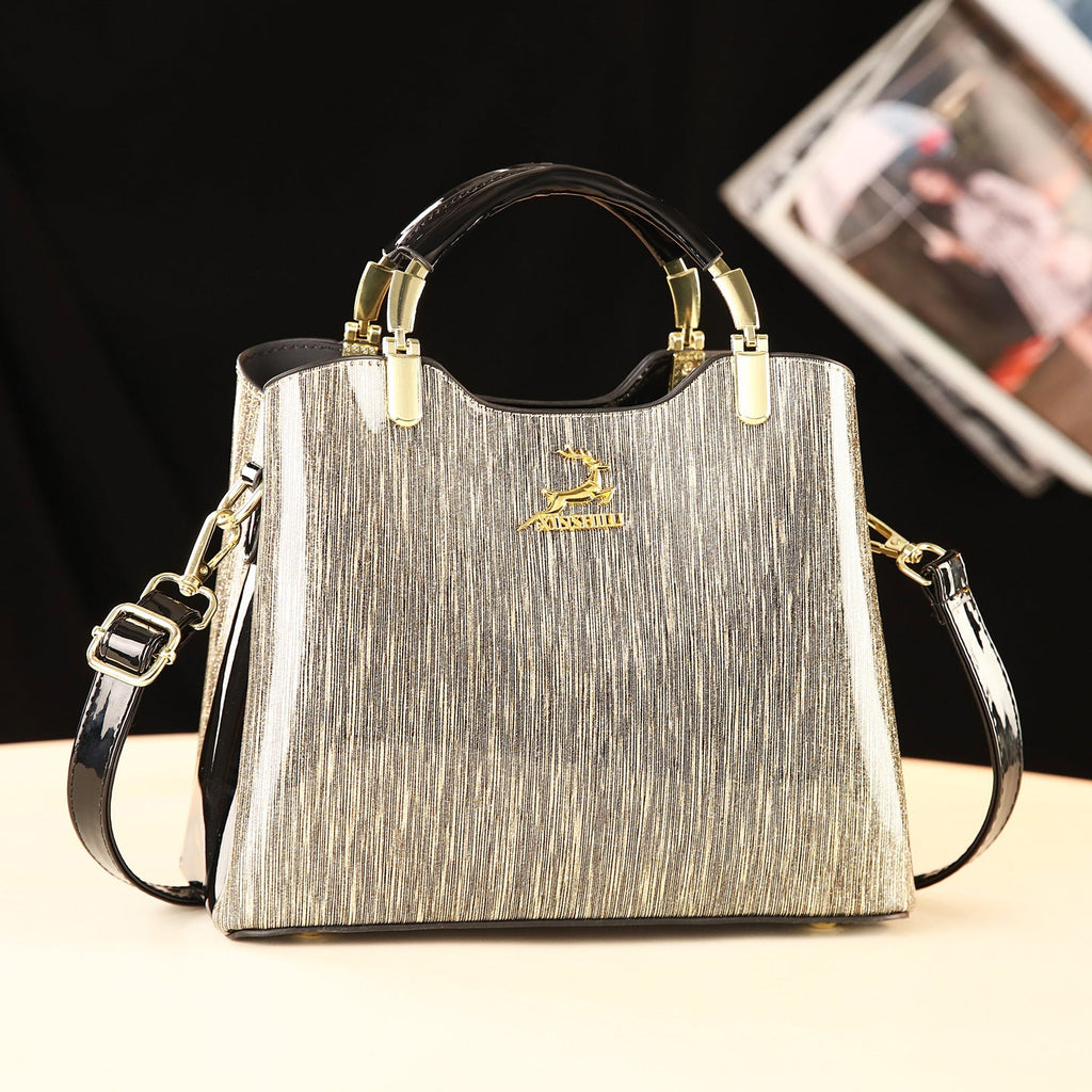 Silver handbag with gold accents on a black background