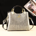 Silver handbag with gold accents on a black background