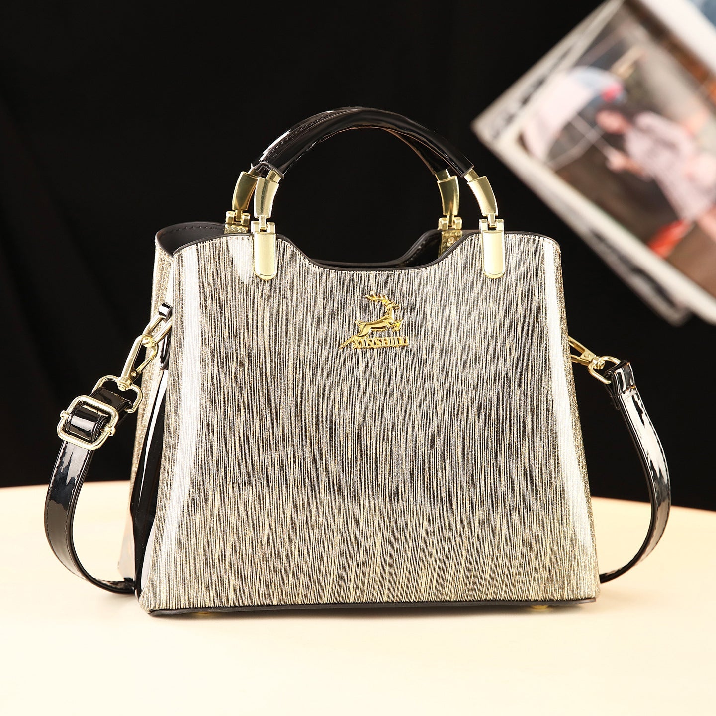Silver handbag with gold accents on a black background